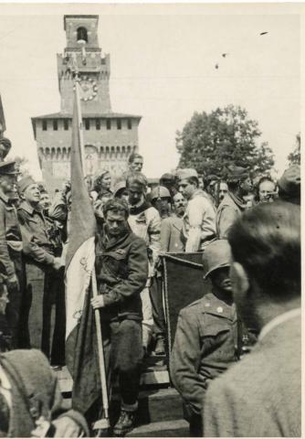 Esposizione della bandiera del C.L.N. all'arrivo in piazza Castello del corteo delle formazioni partigiane, cui prese parte anche la Divisione Flaim. Milano. 6 maggio 1945.